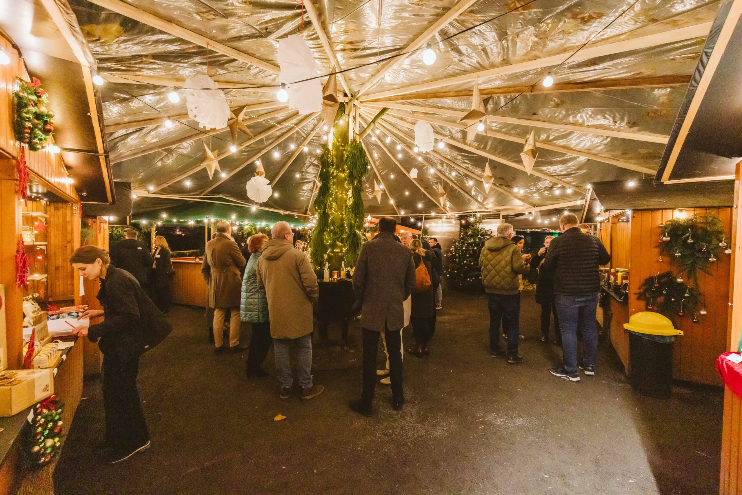 Weitläufige weihnachtliche Eventfläche mit Holzhütten und Lichterketten