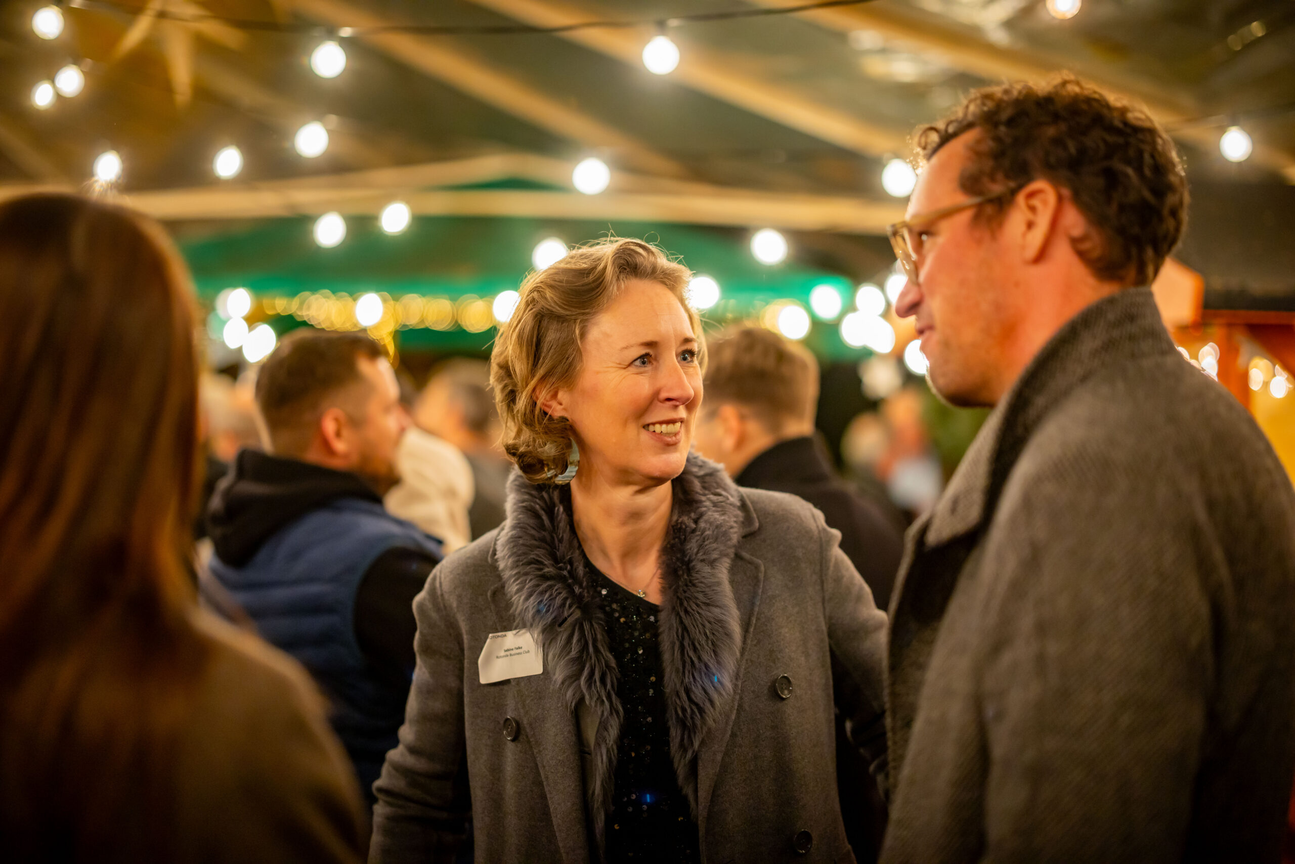 Gäste im Gespräch auf der weihnachtlich beleuchteten Rotonda Eventfläche